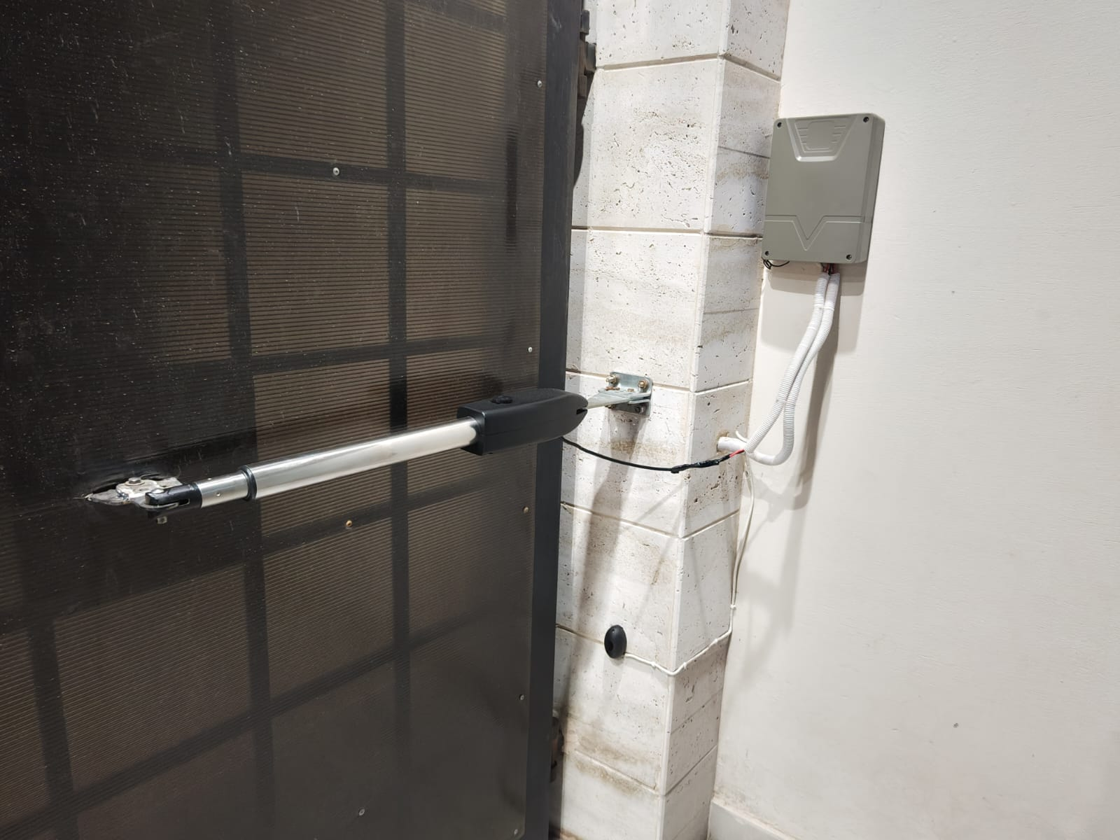 Close-up of swing gate linear actuator arm and control receiver